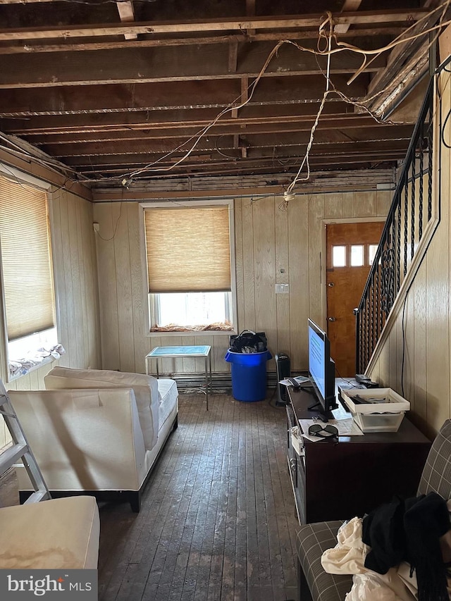 miscellaneous room with dark wood-type flooring and wood walls