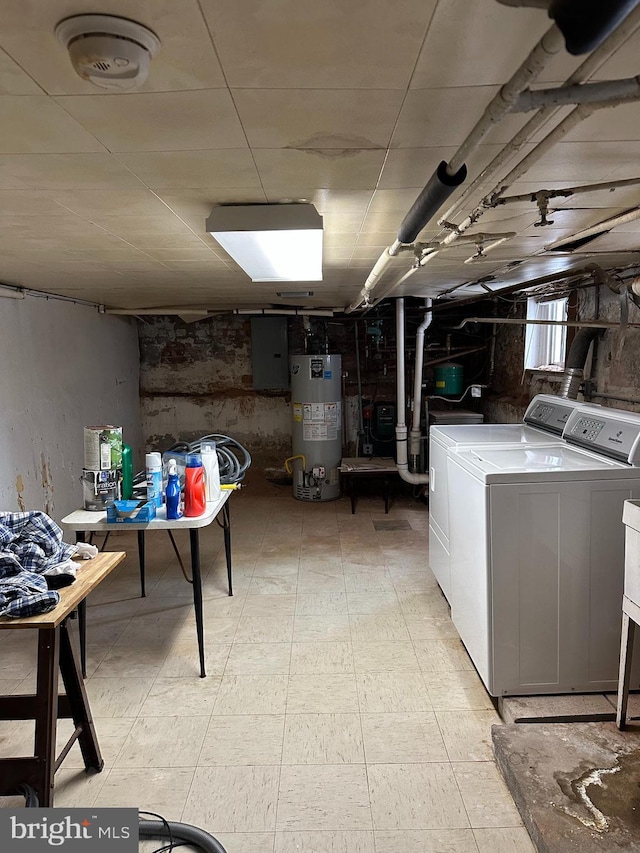 basement featuring washer and dryer, electric panel, and gas water heater