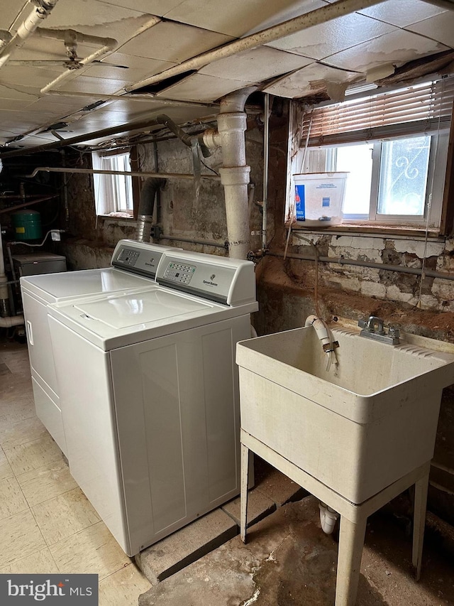 laundry area featuring sink, a wealth of natural light, and washing machine and clothes dryer