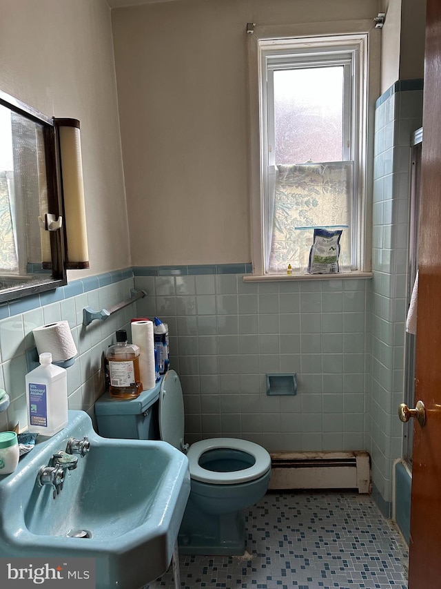 bathroom with tile patterned floors, sink, a baseboard radiator, tile walls, and toilet