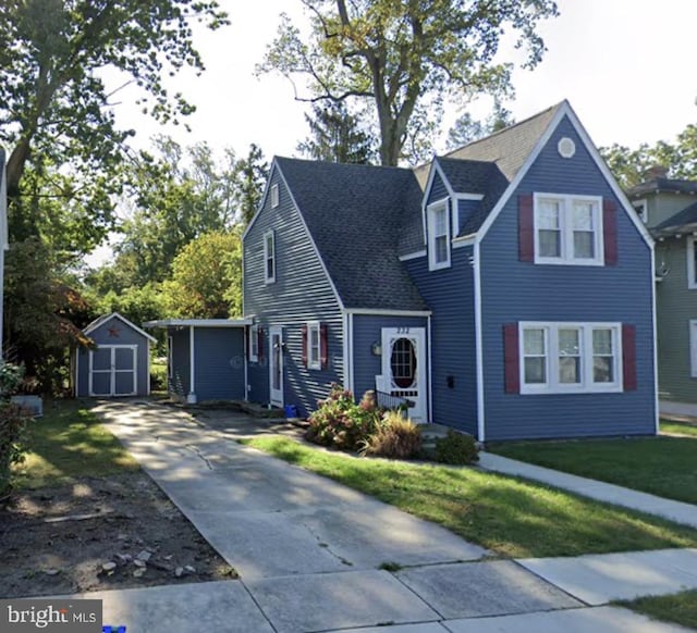 view of front of home featuring a front yard and a shed