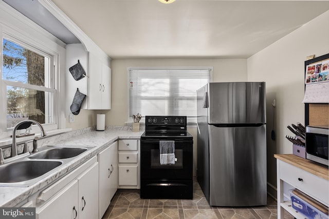 kitchen featuring sink, white cabinetry, plenty of natural light, and appliances with stainless steel finishes