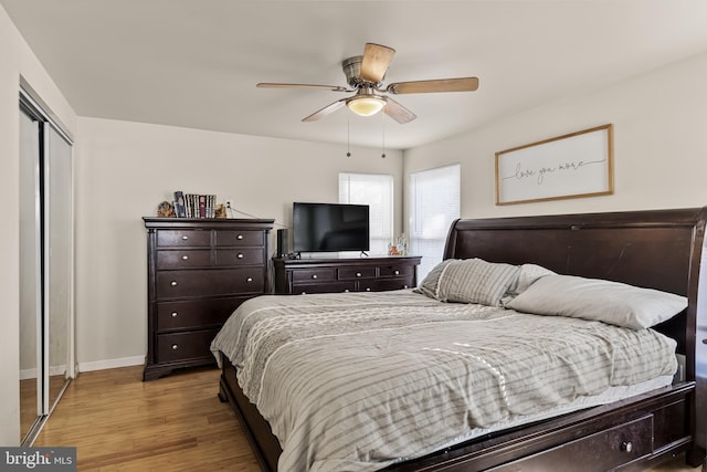 bedroom featuring ceiling fan, light hardwood / wood-style floors, and a closet