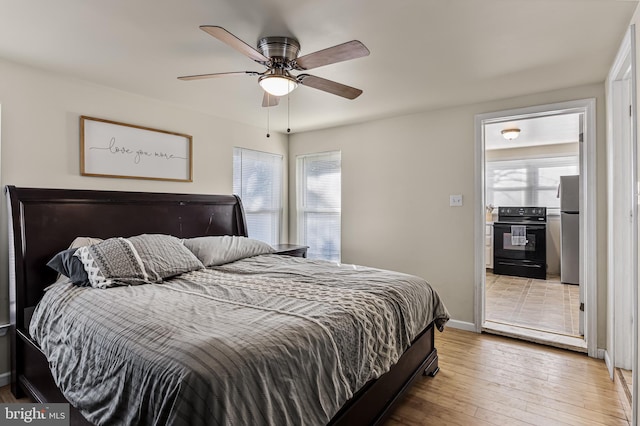 bedroom featuring stainless steel refrigerator, ceiling fan, and wood-type flooring