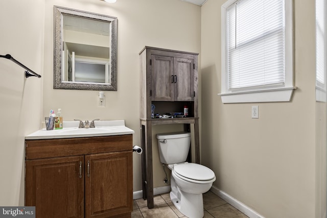 bathroom with vanity, a wealth of natural light, tile patterned floors, and toilet