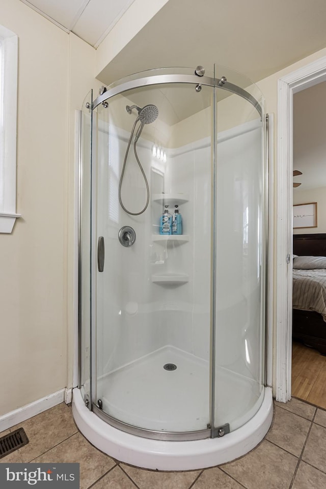 bathroom with an enclosed shower and tile patterned flooring