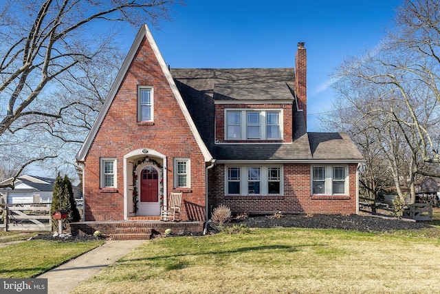 tudor home with a front lawn