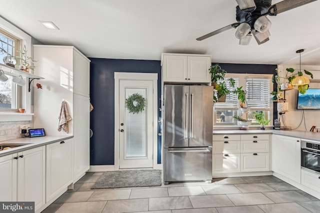 kitchen featuring decorative light fixtures, white cabinetry, and appliances with stainless steel finishes