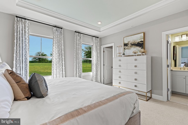 bedroom with a raised ceiling, ensuite bath, light carpet, and sink