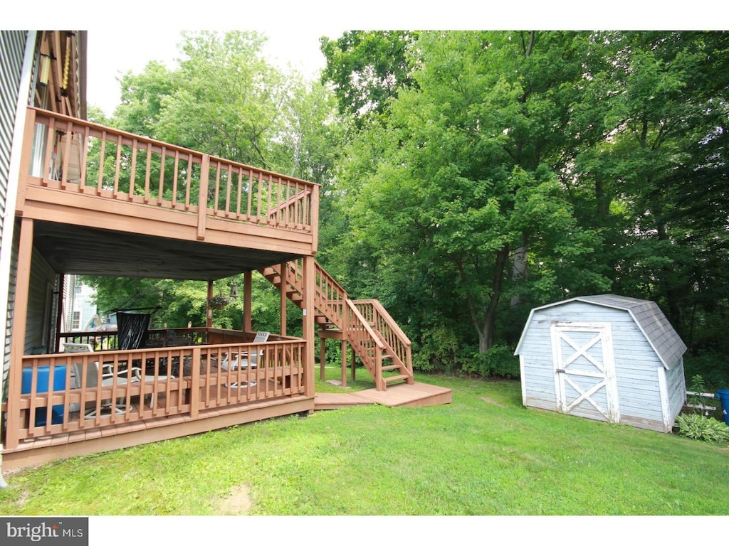 view of yard featuring a storage shed and a wooden deck