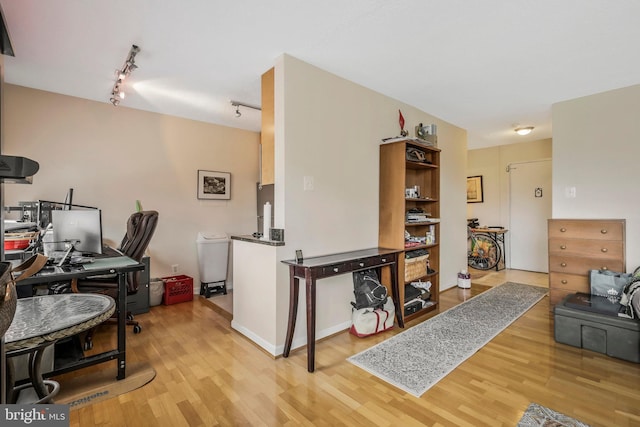 office area with track lighting and light wood finished floors