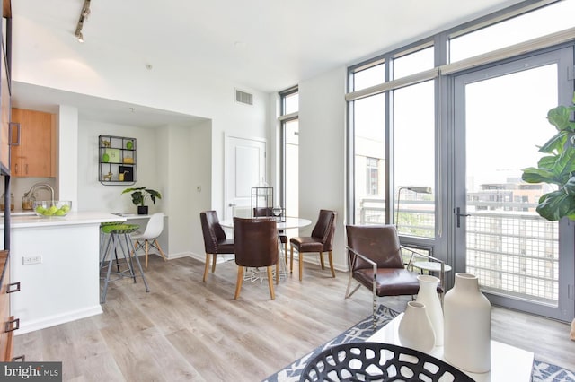 dining area featuring rail lighting and light wood-type flooring