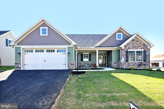 craftsman inspired home featuring a garage, covered porch, and a front lawn