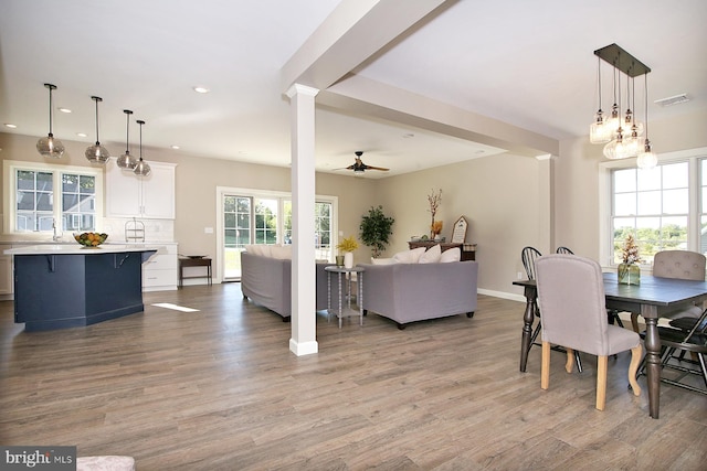 dining room with ceiling fan, light wood-type flooring, and sink