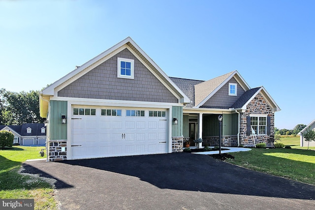 craftsman house featuring a front yard, a porch, and a garage