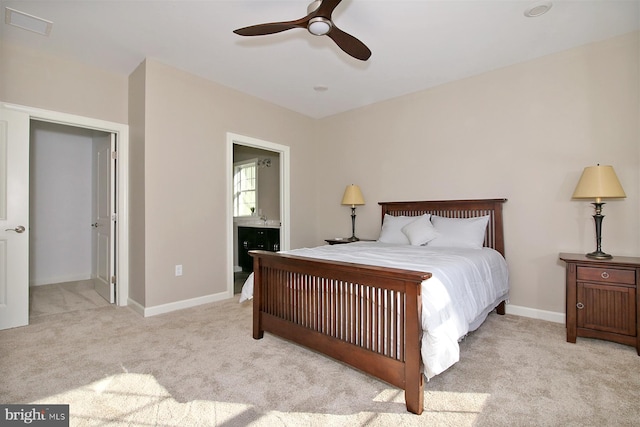 bedroom featuring ceiling fan, light colored carpet, and ensuite bathroom