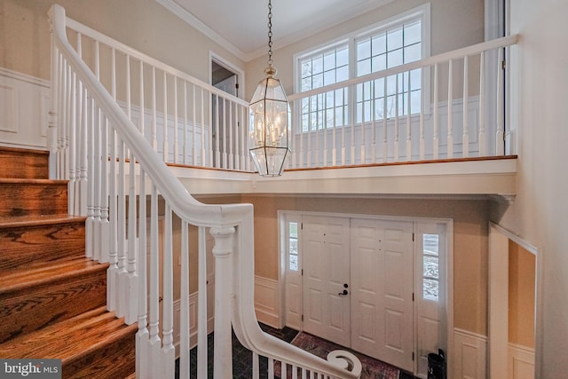 entryway featuring ornamental molding and an inviting chandelier