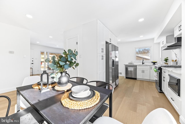 dining room with light hardwood / wood-style floors, a healthy amount of sunlight, and sink