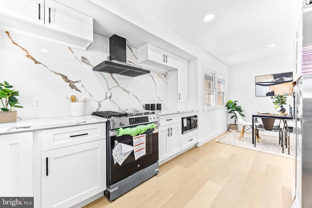 kitchen with gas stove, black microwave, white cabinetry, tasteful backsplash, and range hood