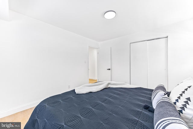 bedroom with wood-type flooring and a closet