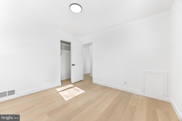 unfurnished bedroom with a closet and light hardwood / wood-style flooring