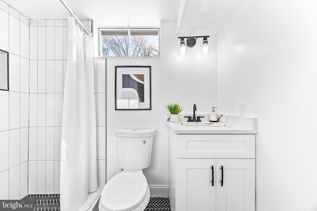 bathroom featuring curtained shower, vanity, and toilet