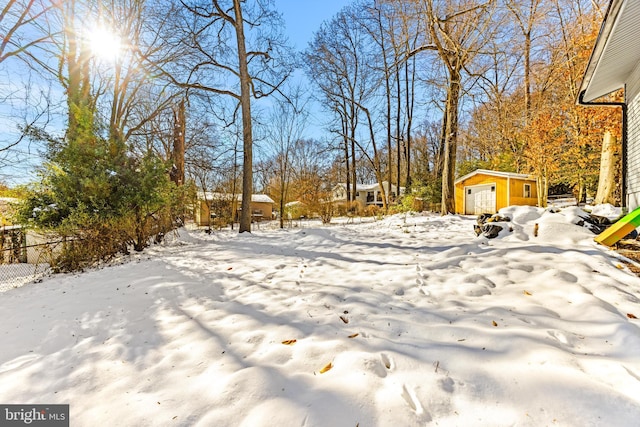 yard layered in snow with an outbuilding