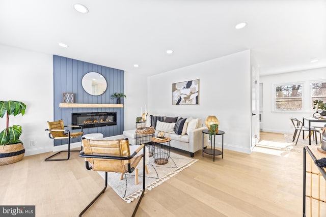 living room featuring light wood-type flooring and a fireplace