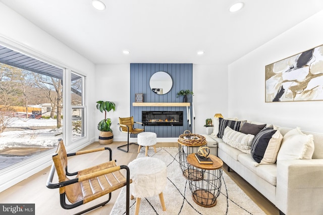 living room with a large fireplace and wood-type flooring