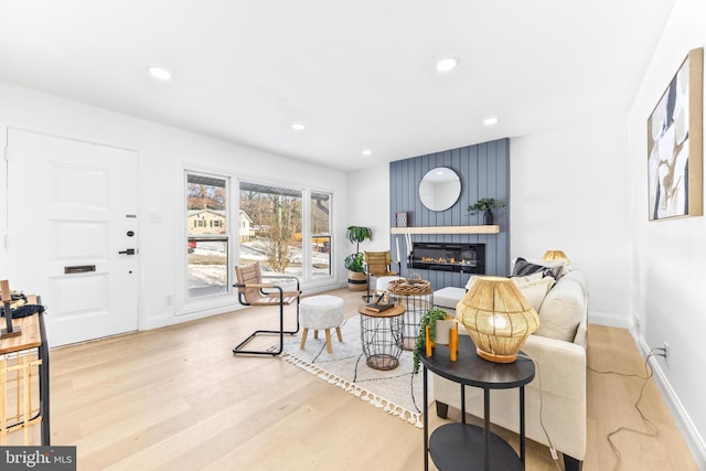 living room with a large fireplace and light wood-type flooring