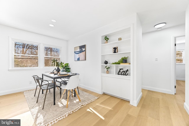 dining space with built in features and light hardwood / wood-style flooring