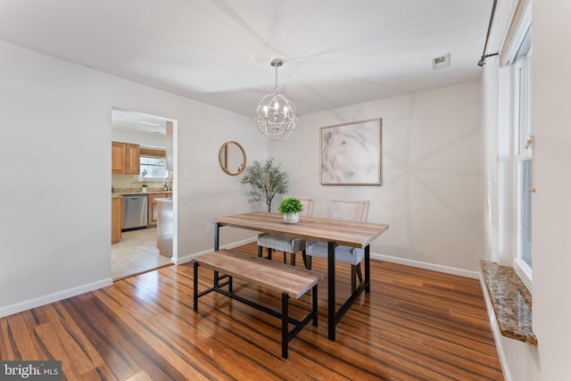 dining room featuring light wood-type flooring and a chandelier