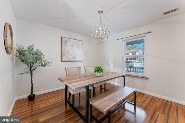 dining room with dark wood-type flooring and a notable chandelier