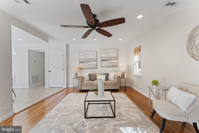 living room featuring ceiling fan and hardwood / wood-style flooring