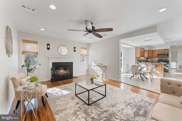 living room with ceiling fan and light hardwood / wood-style flooring