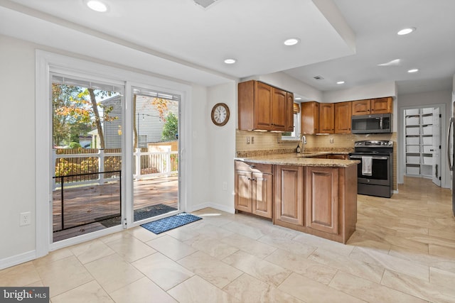 kitchen featuring stainless steel appliances, sink, light stone counters, kitchen peninsula, and backsplash