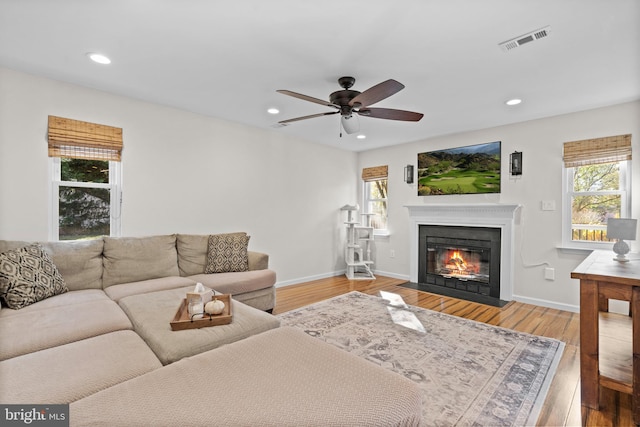living room featuring wood-type flooring and ceiling fan