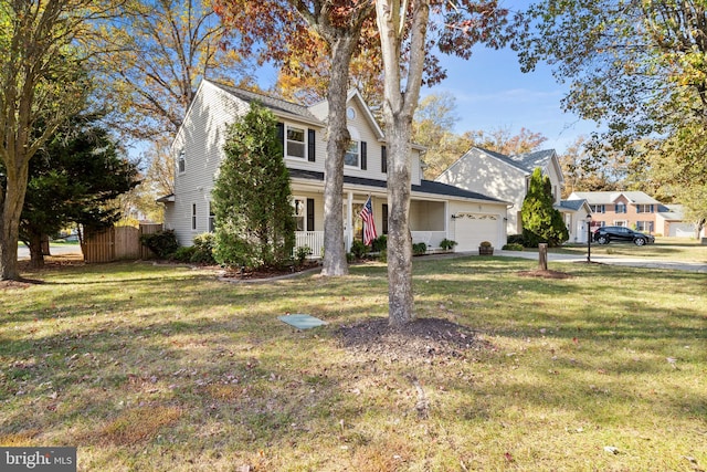 view of front property featuring a front yard, a garage, and covered porch