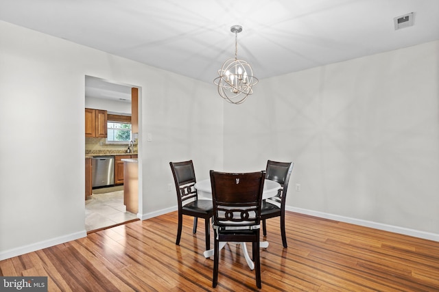 dining room with a notable chandelier and light wood-type flooring