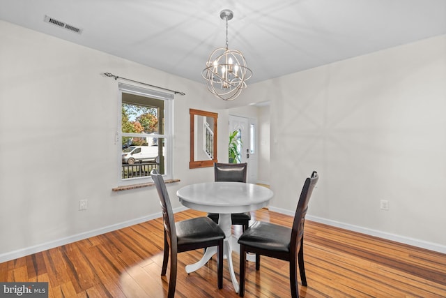 dining space with a chandelier and wood-type flooring