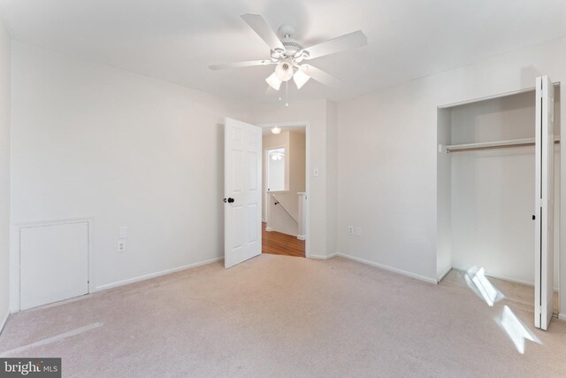unfurnished bedroom featuring a closet, light carpet, and ceiling fan