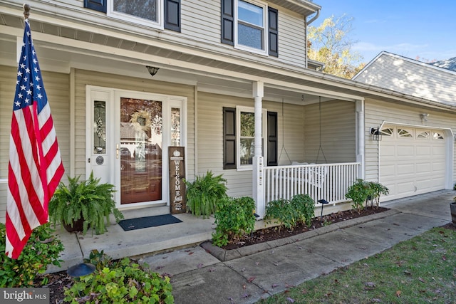 view of exterior entry with a porch and a garage