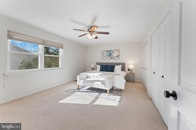 bedroom with a closet, ceiling fan, and light colored carpet