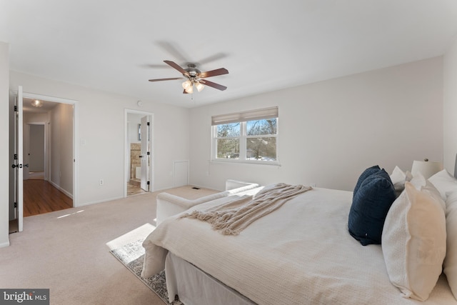 carpeted bedroom with ensuite bath and ceiling fan