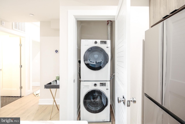 washroom featuring stacked washer and clothes dryer and hardwood / wood-style flooring