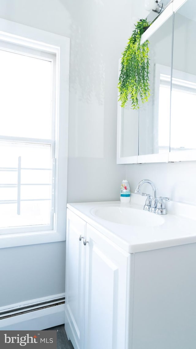 bathroom featuring baseboard heating and vanity