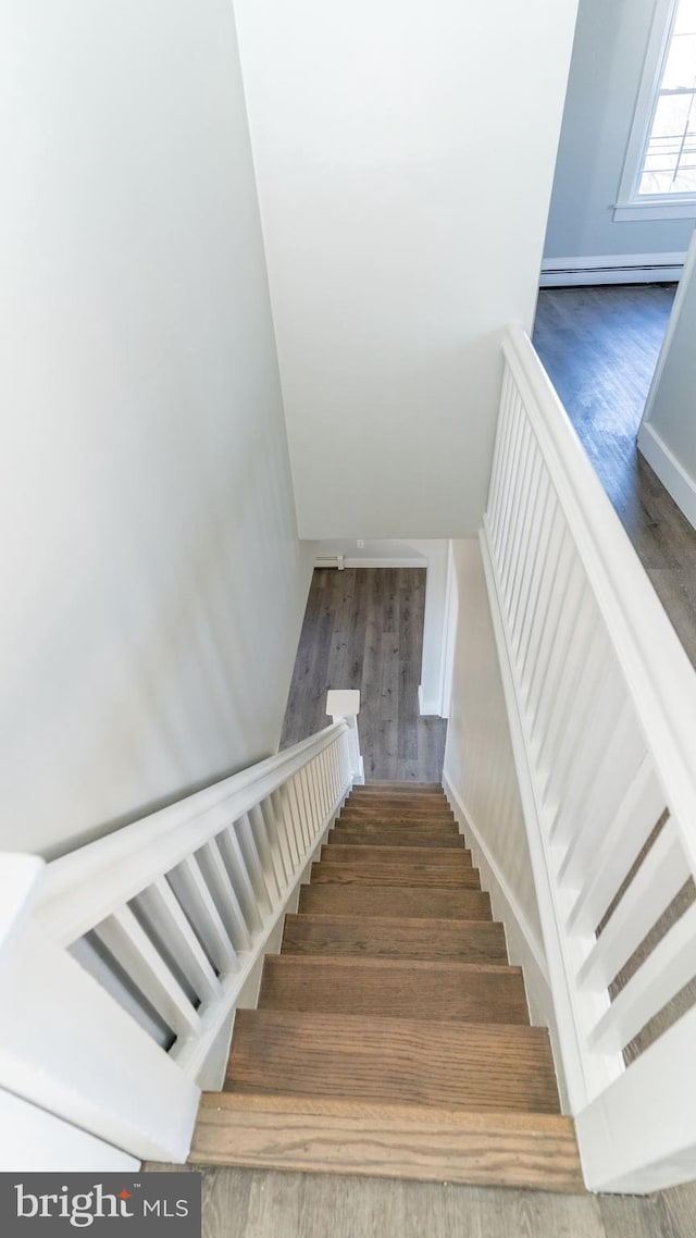 staircase with a baseboard heating unit