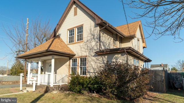 view of side of property with a lawn and covered porch