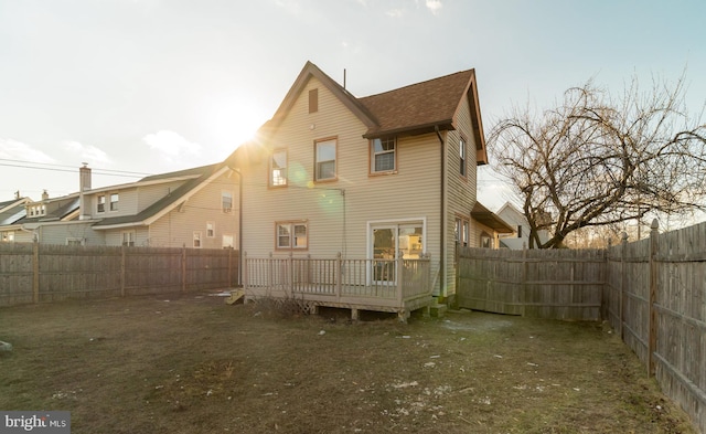 back of property with a lawn and a wooden deck