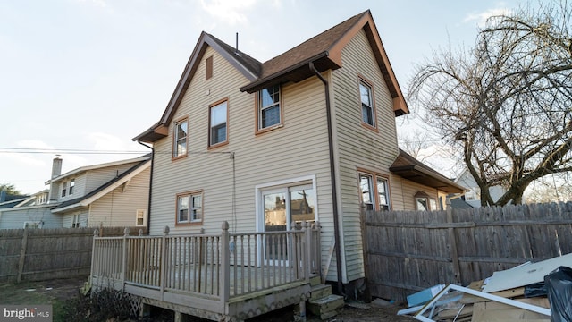 rear view of property featuring a wooden deck